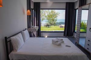a bedroom with a white bed with a large window at SAPANCA JOWA in Sapanca