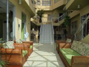 a balcony with wicker chairs and a staircase in a building at Hotel Marux Plaza in Melgar