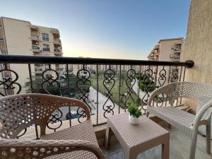 ein Balkon mit Stühlen und Tischen und ein Balkon mit Aussicht in der Unterkunft 2 bedroom apartment in rehab cityy in Burg el-Ḥudûd