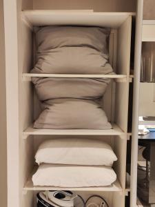 - Armario con almohadas blancas y almohada en Charming studio near from CDG airport, en Roissy-en-France