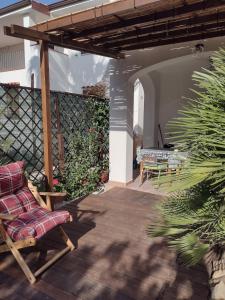 un patio al aire libre con una silla y una mesa en Gardenia House, en Orosei