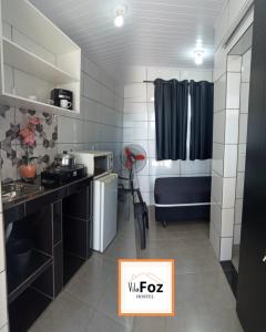 Habitación pequeña con cocina y cama en Vila Foz HOSTEL AP6 Apartamento completo de casal com garagem fechada e lavanderia, Temos Uber e guia turístico para indicar, Nosso apartamento é o melhor custo benefício de Foz do Iguaçu, en Foz do Iguaçu