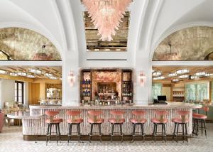 パームビーチにあるPalm House Hotel Palm Beachの広い部屋の赤いスツール付きのバー