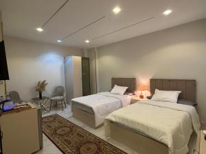 pokój hotelowy z dwoma łóżkami i telewizorem w obiekcie Hapi Pyramids Hotel w Kairze