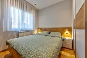 un dormitorio con una cama y una ventana en Srebrna Pahulja Zlatibor centar-Garazno mesto, en Zlatibor