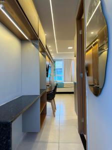 a hallway with a desk and a room with a bed at EcoMirage - Flats Premium - Porto de Galinhas in Porto De Galinhas