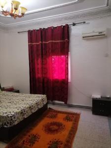 ワルザザートにあるBig flat in ouarzazate city, Moroccoのベッドと赤いカーテンのある寝室