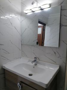 ワルザザートにあるBig flat in ouarzazate city, Moroccoの洗面台と鏡のある白いバスルーム