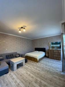 a living room with a bed and a couch at Your Cottage in Borjomi