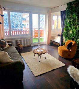 a living room with a couch and a table at Studio au Cœur des Sommets in Crans-Montana
