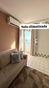 ein Wohnzimmer mit Couch und großem Fenster in der Unterkunft PROMOÇÃO DE INAUGURAÇÃO- 13 andar - vista mar in São José da Coroa Grande