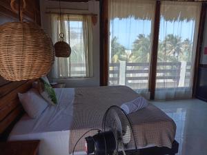 a bedroom with a bed with a view of the ocean at Casa Iguana hotel boutique in El Cuyo