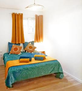 a bedroom with a large bed with orange curtains at Appartement jacuzzi privé à 3 minutes cité médiévale in Carcassonne