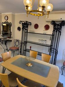 a dining room with a table with chairs and a chandelier at Compound Canarya - 3 Bedroom Apartment in 6th Of October