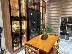 a dining room with a table and a black refrigerator at Duplex luxe a 2 étages dans une Residence privé a el Achour in El Achour