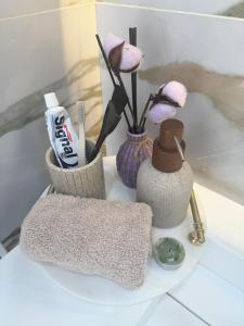 a table with a towel and flowers and a toothbrush at Duplex luxe a 2 étages dans une Residence privé a el Achour in El Achour +14 photos