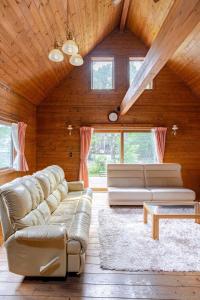 a living room with a couch and a table at 白馬のスキー場まで４分お洒落なログハウス『白馬 MAMMOTH HOUSE』 in Hakuba