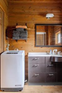 a kitchen with a white refrigerator and a sink at 白馬のスキー場まで４分お洒落なログハウス『白馬 MAMMOTH HOUSE』 in Hakuba