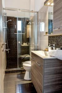 a bathroom with a shower and a toilet and a sink at Angela Apartments in Kato Daratso