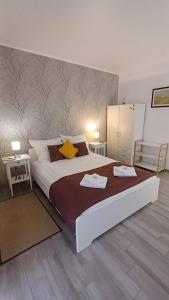 a bedroom with a large bed with two towels on it at Neferprod Apartments - IS - CAM 03 in Timişoara