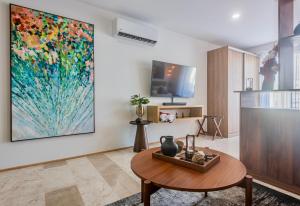 プラヤ・デル・カルメンにあるPlaya Azul Studio - Coco Beach Iの大きな絵画が飾られたリビングルーム
