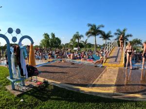 a crowd of people sitting around a swimming pool at La Casa Bubba in Federación