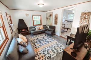 a living room with a couch and a television at Bee-happy rustic cabin in Arkdale