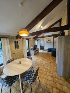 Una sala de estar con una mesa y sillas y un sofá. en Le Longbeach 2, en Longueville