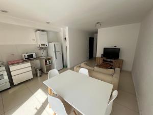 a kitchen and living room with a white table and chairs at Departamento nuevo en el centro in Mar del Plata