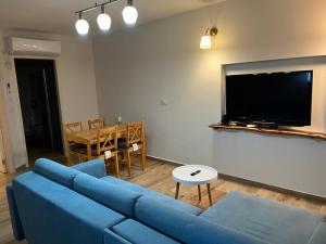 a living room with a blue couch and a table at נוף לעמק in Bruchim Qela' Alon