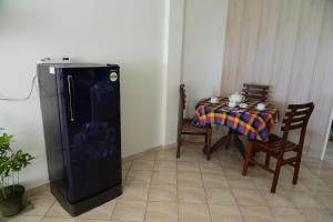 a small refrigerator in a room with a table at Happy Tuna Beach Apartment in Hikkaduwa