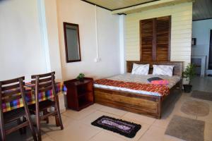 a bedroom with a bed and a table and chairs at Happy Tuna Beach Apartment in Hikkaduwa