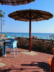 a table and chair under an umbrella on the beach at Apartman Viktoria in Vir
