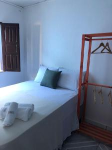 Un dormitorio con una gran cama blanca en una habitación. en Casa confortável e aconchegante, en Lençóis