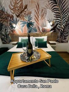 un tavolo con una bottiglia e due bicchieri di vino sopra di San Paolo Casa Bella a Roma