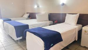 Postel nebo postele na pokoji v ubytování Rede Andrade Estrela Dalva Centro Hotel