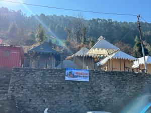 a wall with a sign on top of it at Morning Glory Camping and trekking in Joshīmath