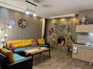 a living room with a couch and a fireplace at Villa Sun Valley in Bakuriani