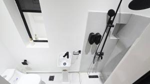 a white bathroom with a toilet in a room at Oasis Moods Holiday Homes in Al Ain
