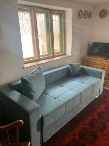 a blue couch in a living room with a window at Casa La Casiru 6 in Straja
