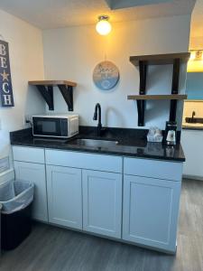 a kitchen with a sink and a microwave at Nautical Motel in Hampton