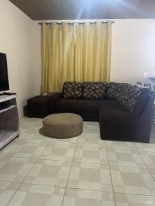 a living room with a black couch and a tv at Casa Refúgio da Paz in Lumiar