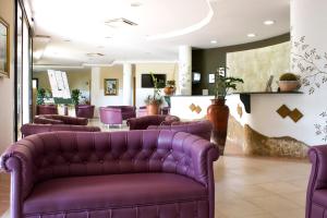 una sala d'attesa con divani in pelle viola e un salone di Villaggio Spiagge Rosse a Capo Rizzuto