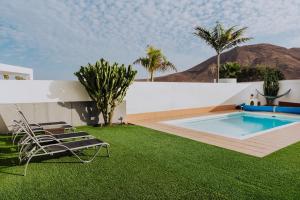 a backyard with a swimming pool and grass at Villa Lanzarote Deluxe & Spa Pool in Playa Blanca +125 photos