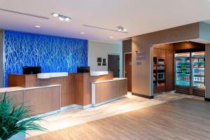 an office lobby with a reception desk and a blue wall at Fairfield Inn & Suites by Marriott Indianapolis Carmel in Carmel +10 photos