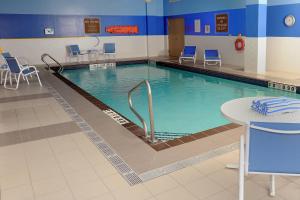 a large swimming pool with chairs and a table at Four Points by Sheraton Cambridge Kitchener, Ontario in Cambridge