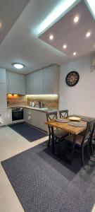 a kitchen with a table and chairs in a room at Apartman Tivat - Centar 1 in Tivat