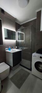 a bathroom with a toilet and a sink and a washing machine at Apartman Tivat - Centar 1 in Tivat