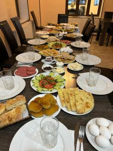 a long table with plates of food on it at Hotel Svanseti in Mestia