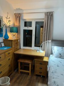a bedroom with a desk with a bed and a window at House in city centre with free parking in Cambridge